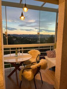 Duplex Panorâmico com vista incrível! Morro do Elefante! في كامبوس دو جورداو: شرفة بها طاولة ودبّان صغيران عليها