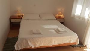a bedroom with a bed with two towels on it at Apartment Dobri in Batalaži