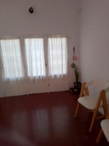 a living room with white curtains and a table at Casa María Josefina in Rosario