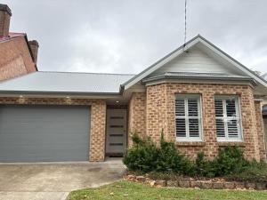 a brick house with a garage at The Goldsmith Retreat in Goulburn