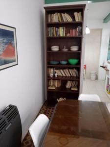 a dining room with a table and a book shelf at Casa María Josefina in Rosario