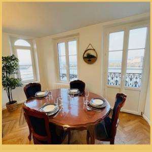Un comedor con mesa y sillas de madera. en L'Embar'quai, en Le Tréport