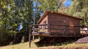 a log cabin with a porch and a deck at Cabana Los Arrayanes in Coihueco