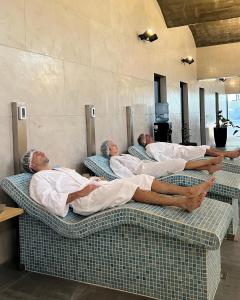 three men laying on beds in a room at TERMAS PISMANTA Hotel & Spa in Las Flores