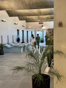 a couple of people walking through a lobby at TERMAS PISMANTA Hotel & Spa in Las Flores +59 photos