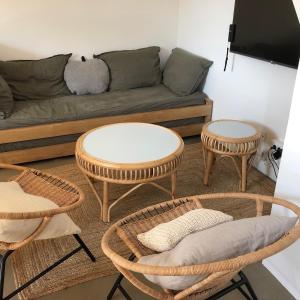- un salon avec deux tables et un canapé dans l'établissement Ma petite maison d hotes - Dunes Cottages - Le Touquet, à Le Touquet-Paris-Plage