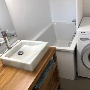 une salle de bain avec un lavabo et une machine à laver dans l'établissement Ma petite maison d hotes - Dunes Cottages - Le Touquet, à Le Touquet-Paris-Plage 17 autres photos