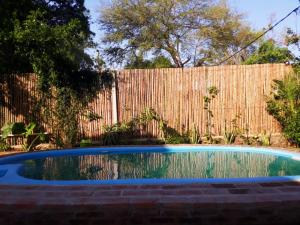 a swimming pool in front of a fence at Cabañas Carayá II in Paso de la Patria