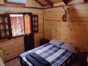 a bedroom with a bed in a log cabin at Cabañas Carayá II in Paso de la Patria