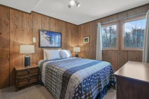una camera da letto con pareti in legno, un letto e una finestra di Slope Side VillasI Alpen Villas at Powderhorn Mountain a Bessemer