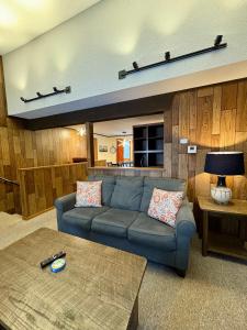 a living room with a blue couch and a table at Retro Ski-In Ski-Out Villa at Powderhorn Mountain in Bessemer