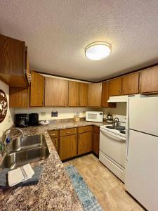 a kitchen with wooden cabinets and a white refrigerator at Alpen Villa Escape at Powderhorn Mountain in Bessemer
