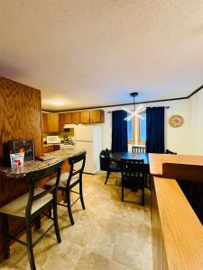 a kitchen and dining room with a table and chairs at Alpen Villa Escape at Powderhorn Mountain in Bessemer +9 photos