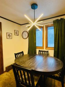 a dining room with a table and a clock on the wall at Premium Slope-Side Escape I Alpen Villas at Powderhorn Mountain in Bessemer
