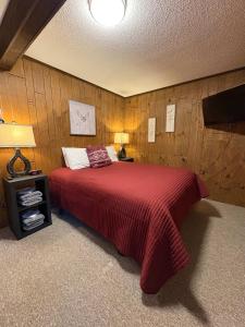 a bedroom with a large bed with a red blanket at Premium Slope-Side Escape I Alpen Villas at Powderhorn Mountain in Bessemer +14 photos