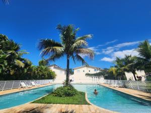 a palm tree in the middle of a swimming pool at Villa di Prado in Juquei