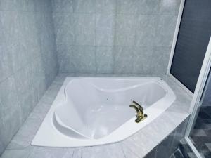 a bath tub with a faucet in a bathroom at Day And Night Hotel Belmopan in Belmopan +39 photos
