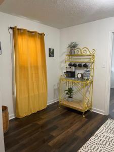 a room with a yellow curtain and a yellow shelf at Downtown Yellow Room at Villages on Aurora in Ironwood