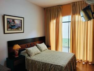 a bedroom with a bed and a large window at Tambo II Hotel Campestre in Cieneguilla +40 photos
