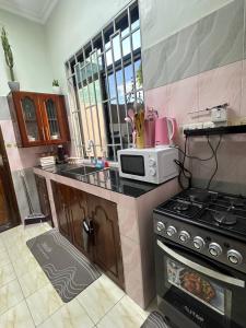 una cucina con fornelli e microonde di Blue wave loft a Dar es Salaam