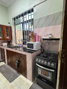 una cucina con fornelli e microonde di Blue wave loft a Dar es Salaam Altre 61 foto