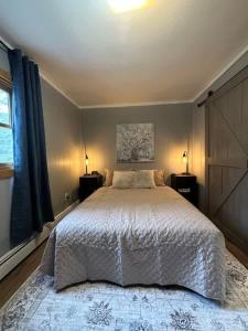 a bedroom with a large white bed with two lamps at Snowbound Bliss at Powderhorn Mountain in Bessemer