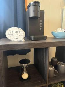 a coffee maker on a wooden shelf with a sign at Elevated Ski Chalet at Powderhorn Mountain in Bessemer