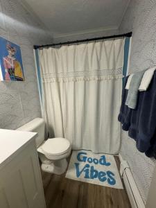 a bathroom with a toilet and a sign that says good vibes at Elevated Ski Chalet at Powderhorn Mountain in Bessemer