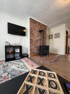 a living room with a fireplace and a brick wall at Skiing in Style at Powderhorn Mountain in Bessemer