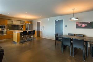 a kitchen and dining room with a table and chairs at Downtown Queenstown Apartment in Queenstown