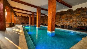 a swimming pool in a building with a stone wall at Le Suisse Spa in Santa Lucía Milpas Altas