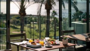 a table with food on it with a view of the ocean at Las Terrazas de Abama Suites in Guía de Isora