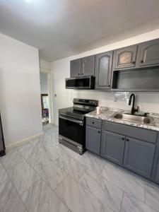 a kitchen with a stove and a sink at Preston Serenity Room With Shared Bath & Kitchen in Hartford