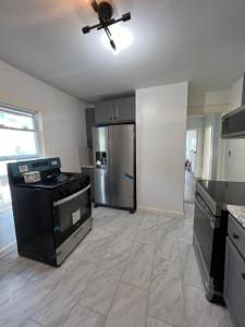 a kitchen with a refrigerator and a ceiling fan at Preston Serenity Room With Shared Bath & Kitchen in Hartford