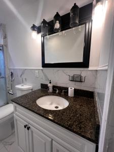 a bathroom with a sink and a mirror at Preston Serenity Room With Shared Bath & Kitchen in Hartford