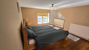 a bedroom with a bed and a window at Longden Court Mews in Buxton