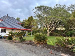 a house with a garden next to a street at RUs Terraces in Kauri