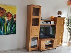 un centro de entretenimiento de madera con TV en la sala de estar en Apartment Sonneninsel, en Zinnowitz