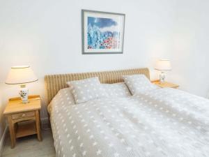 a bedroom with a bed and two night tables with lamps at Schleitraum Lindaunis Cozy Getaway in Lindaunis