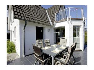 a dining table and chairs on a patio at Schleitraum Lindaunis Cozy Getaway in Lindaunis