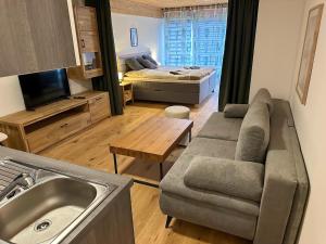 a living room with a couch and a bed at Apartment in Saalfelden near Ski Slopes in Saalfelden am Steinernen Meer