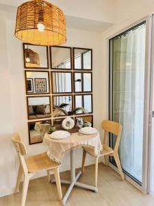 una sala da pranzo con tavolo, sedie e una finestra di Azure Staycation by Maxan a Manila