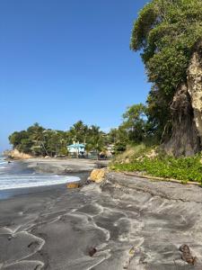 a black beach with footprints in the sand at Grace's Place in Sapphire