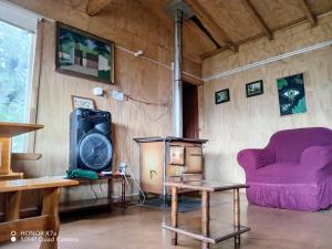 sala de estar con sofá púrpura y silla en cabañita Campestre, independiente, en Castro