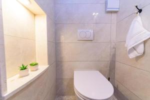 a bathroom with a white toilet and a towel at Apartments with WiFi Bol, Brac - 23862 in Bol +10 photos