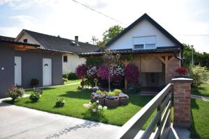 une maison avec un jardin avec des fleurs dans la cour dans l'établissement Apartments with parking space Valpovo, Slavonija - 24020, à Valpovo