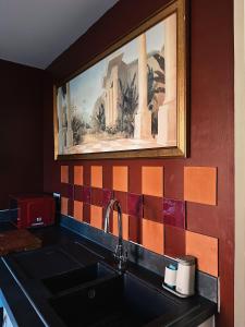 a kitchen with a sink and a painting on the wall at Villa Noria in Kingston Bagpuze