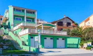 dom z dwoma drzwiami garażowymi przed nim w obiekcie Villa Drago w Marinie