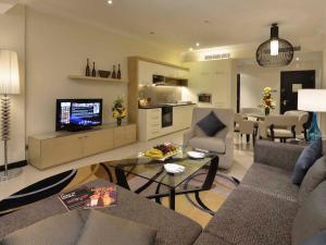 غولف اكزيكتيف ريزيدنس في المنامة: غرفة معيشة مع أريكة وطاولة مع تلفزيون