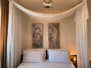 a bedroom with a bed with two paintings on the wall at Villa Noria in Kingston Bagpuze